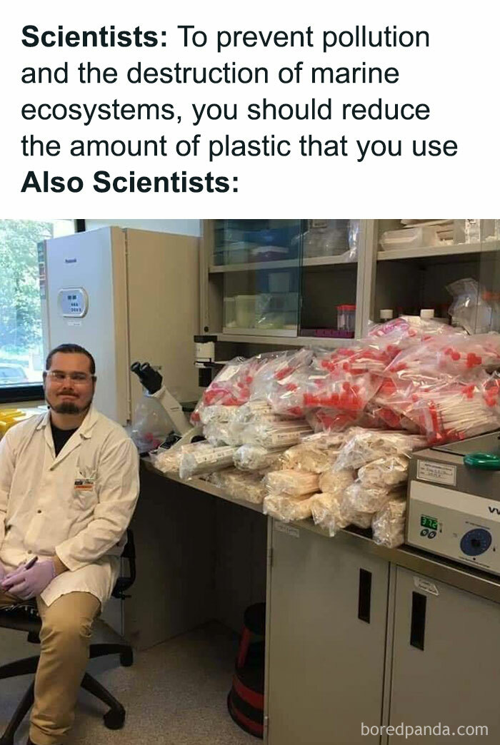 Scientist sitting in a lab surrounded by large piles of single-use plastic tubes, illustrating science memes humor and irony.