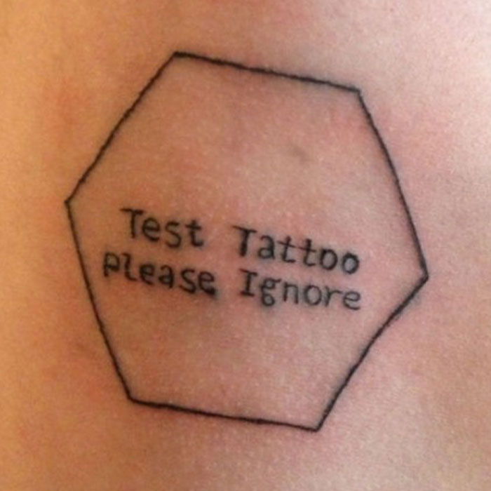 Hexagonal tattoo with the words Test Tattoo Please Ignore, showcasing one of the most funny tattoo fails shared online.