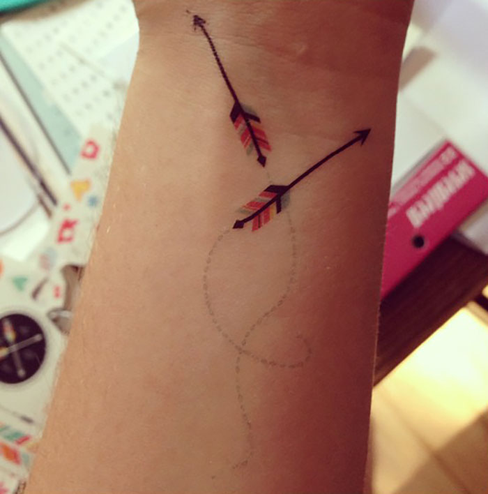 Arrow-themed wrist tattoo with vibrant colors making a statement.