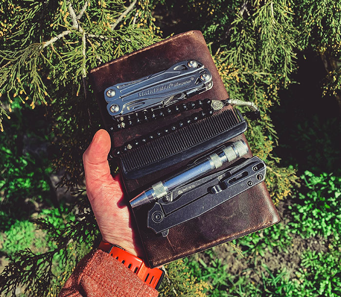 Man holding a multitoolleather case with equipment