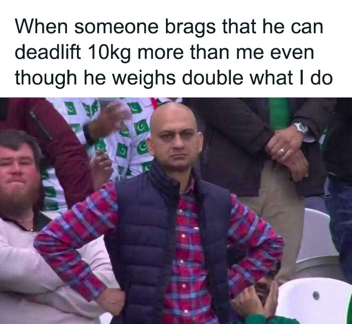 Confused man with hands on hips at a sports event, illustrating gym meme humor for gym rats.