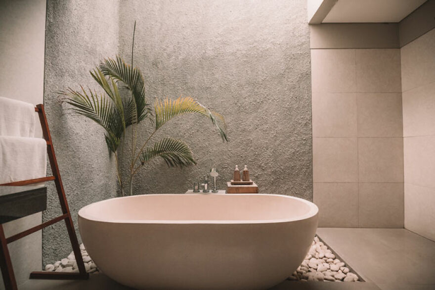 Bathtub next to a plant 