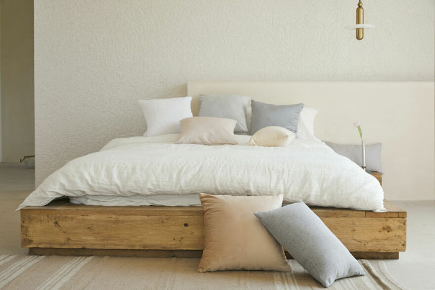 Wooden bed with white bedsheets 