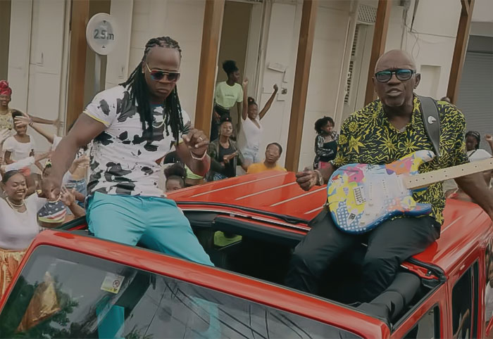 Admiral T Ft. Jacob Desvarieux performing on the red car in Chat Ka Tété Rat music video