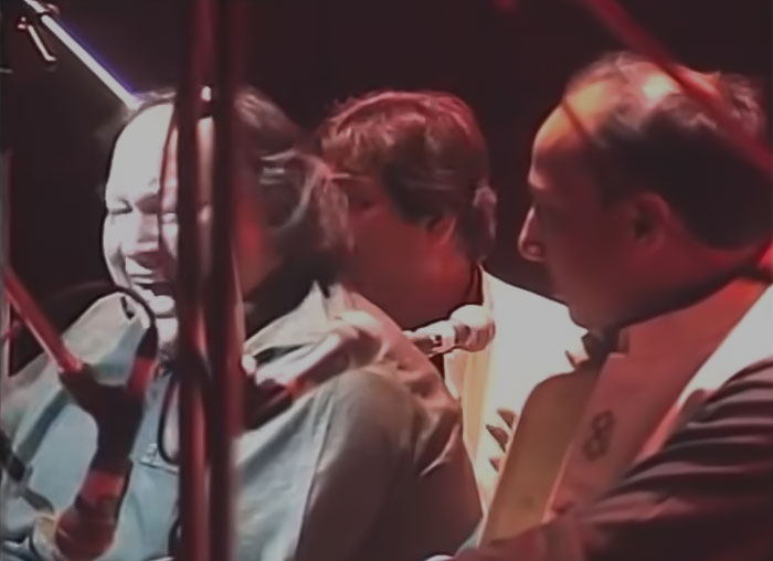 Image from Nusrat Fateh Ali Khan - Dam Mast Qalandar concert, three man are performing