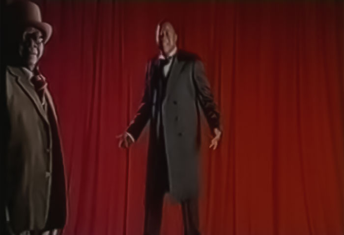 Image from Papa Wemba - Yolele, two man in classy wear performing in front of red curtains