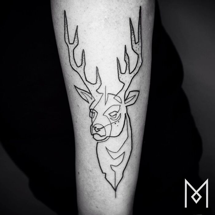Single line deer tattoo art on a person's forearm, showcasing minimalistic and captivating design.