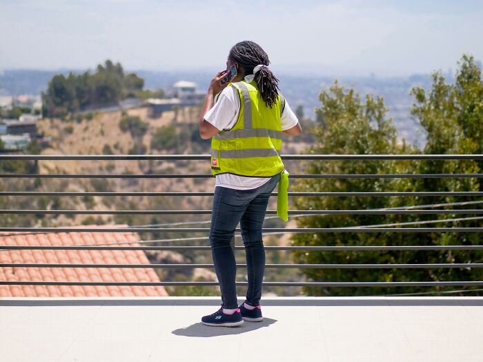 Woman standing on balcony and talking in the phone 