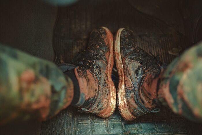 Person sitting in a car with dirty shoes 