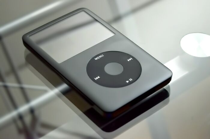 Apple iPod placed on a glass table, representing one of the old gadgets that were trendsetters of their time.