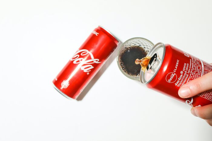 Person Pouring Coca Cola In The Glass 