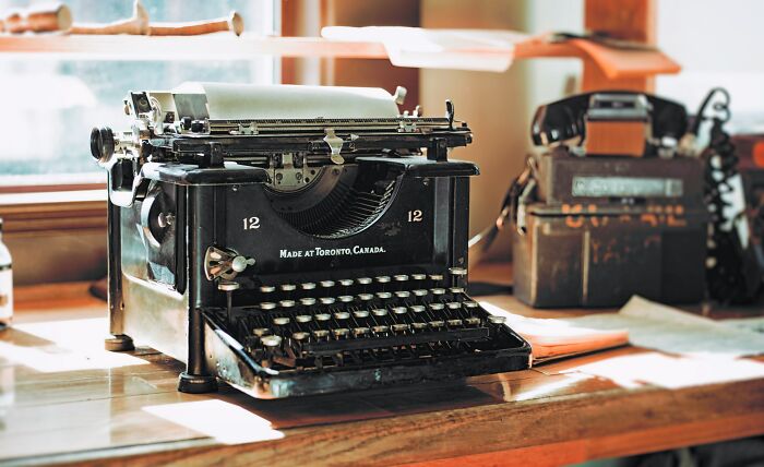 Vintage typewriter on a wooden table, showcasing classic old gadgets that were the trendsetters of their time.