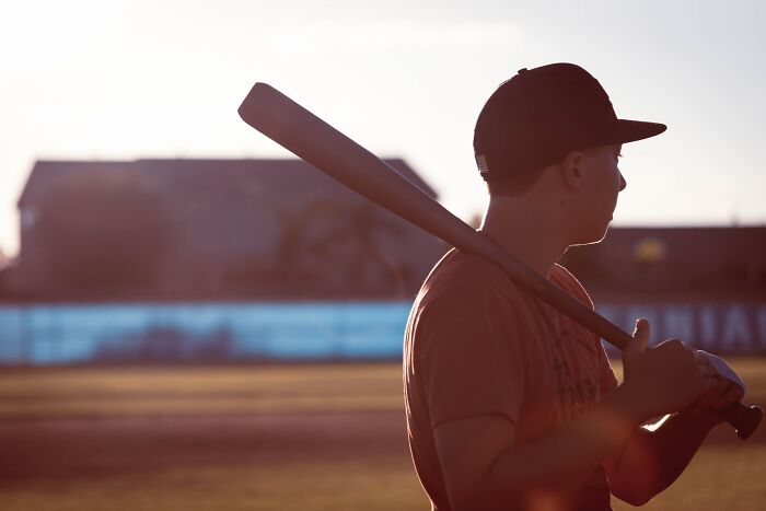 Man standing with a bat and a helmet 