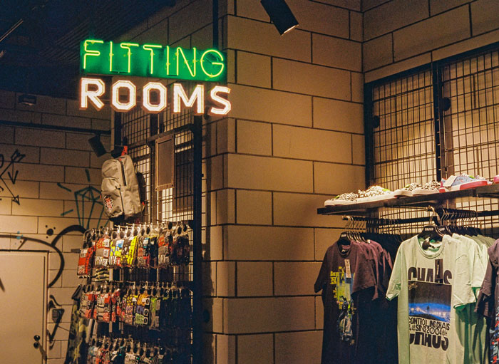 Clothes hanging on hangers near fitting room
