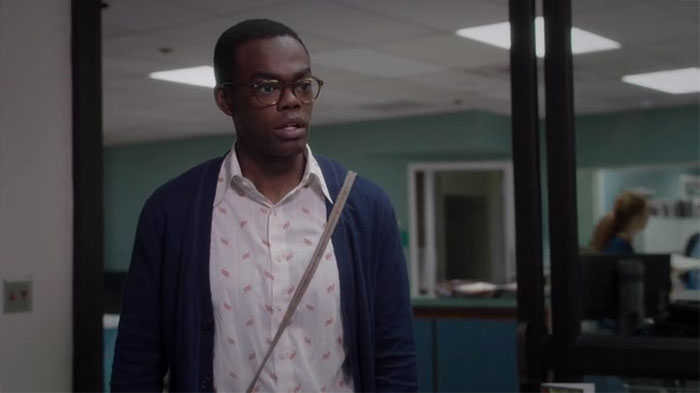 Chidi wearing blue sweater and white shirt 