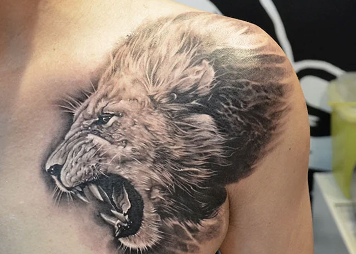 Lion tattoo design on shoulder, often seen as lacking creativity according to popular online opinions.