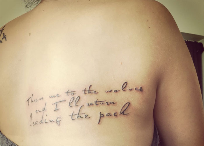 Tattoo design on a person's back with text, considered lacking creativity by some online.