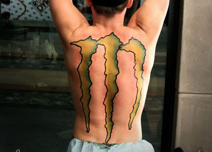 Person with large yellow and green back tattoo design that is often seen as lacking creativity.