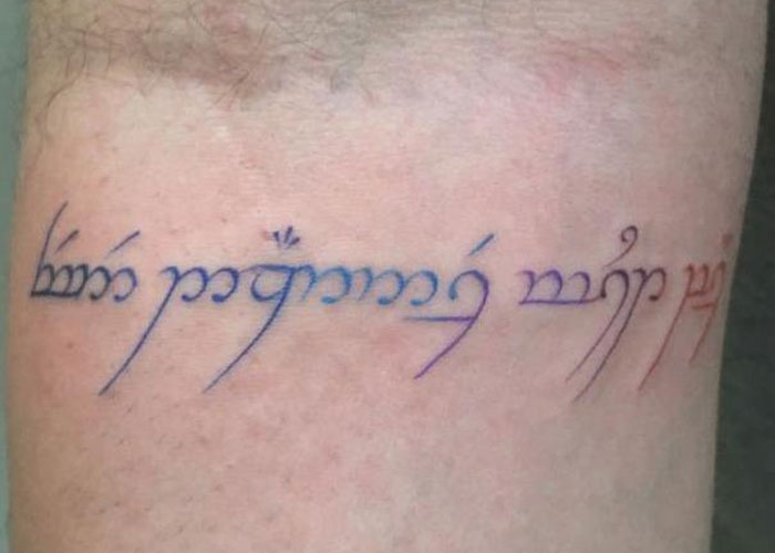 Tattoo design with text in stylized script on skin, resembling commonly seen creative tattoos.