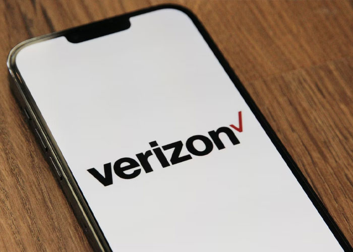 Smartphone displaying Verizon logo on wooden surface, emphasizing the weirdest rule while a guest at someone's house.