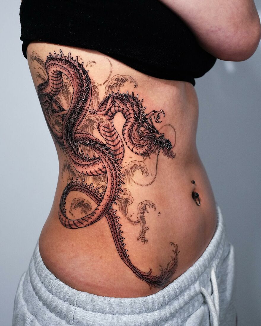 Detailed dragon tattoo wraps around a person's side, showcasing intricate design elements.