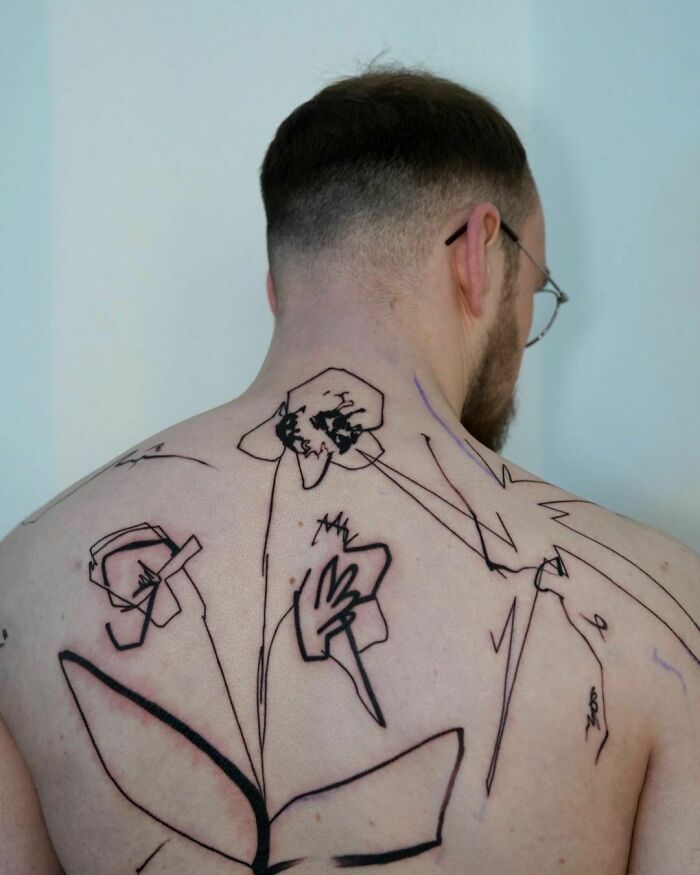 Tattoo artist's abstract back piece, gaining 2.5M viral views for unexpected reasons.