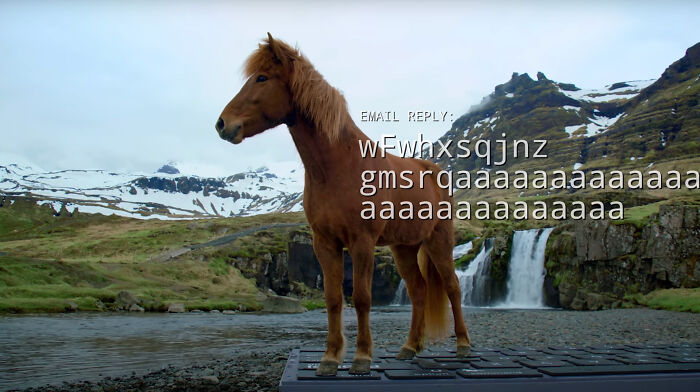 Icelandic horse standing on a giant keyboard in a scenic landscape, appearing to type an email reply.