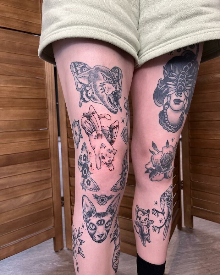 Tattooed legs featuring various patchwork designs including cats, flowers, and butterflies.