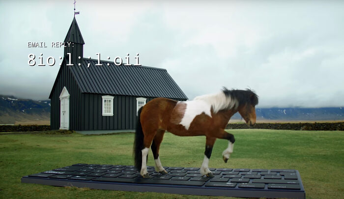 Icelandic horse standing on a giant keyboard near a black chapel with mountains in the background.
