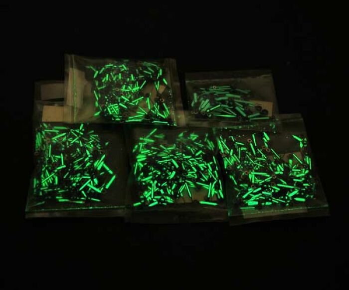 Glow sticks in clear plastic bags glowing bright green in a dark setting representing a worst trend discussion.
