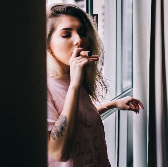 Girl Smoking A Cigar Inside A House 
