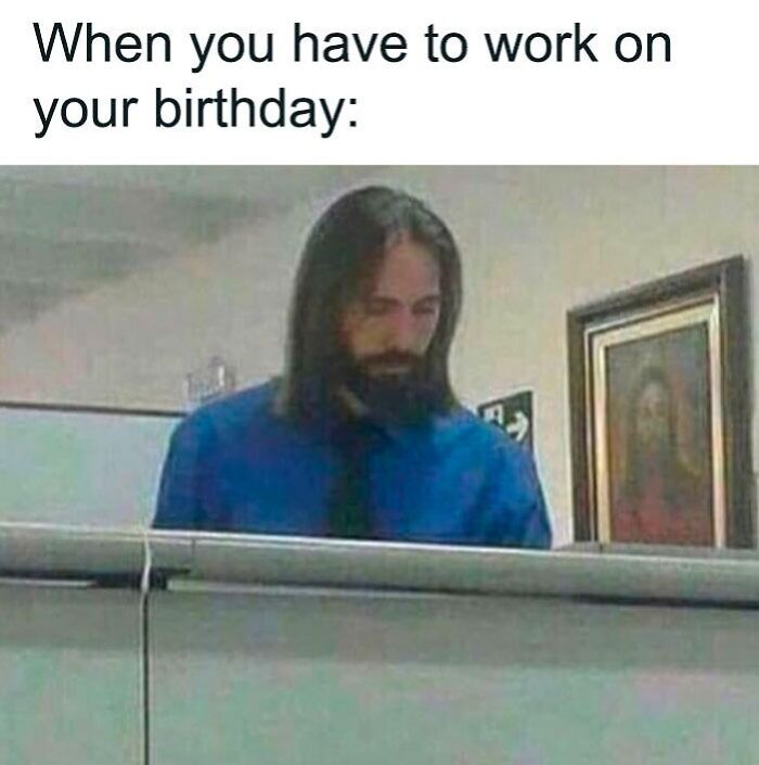 Man in a blue shirt at work desk with a humorous happy birthday meme text above.