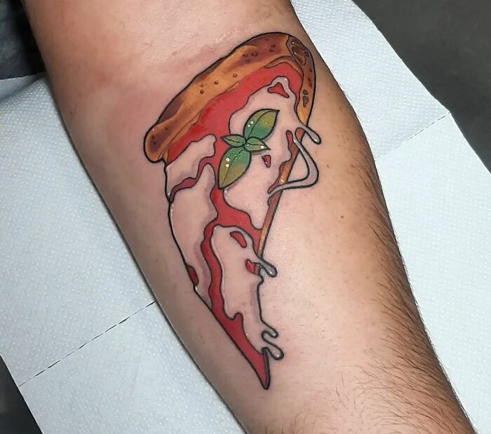 Watercolor pizza slice tattoo on someone's arm, showcasing vibrant food ink-spiration.