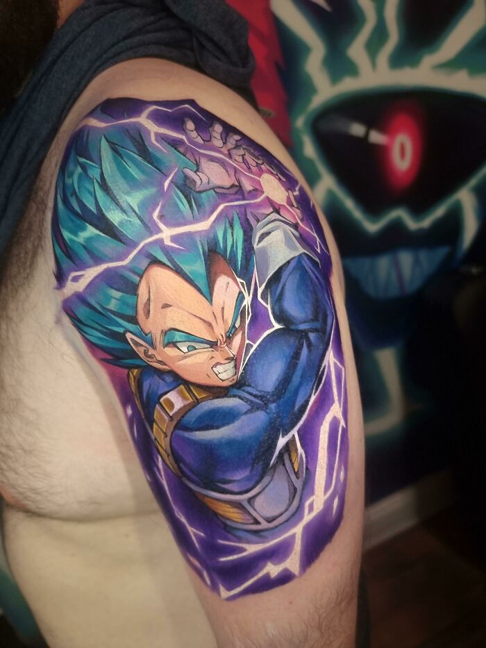 Vibrant pop culture tattoo on arm featuring a dynamic anime character with electric blue hair and intense expression.