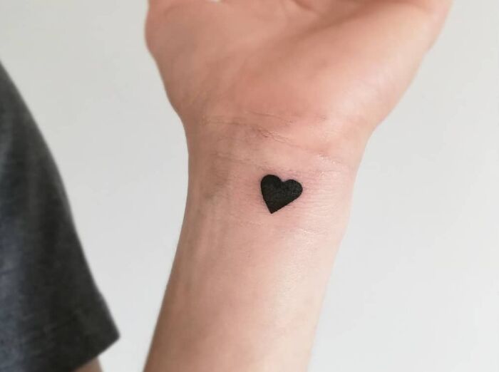 Minimalist heart wrist tattoo design on skin.