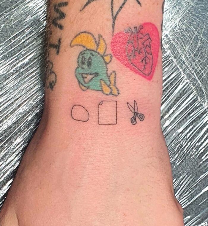 Colorful wrist tattoo designs featuring a fish, heart, and geometric shapes.