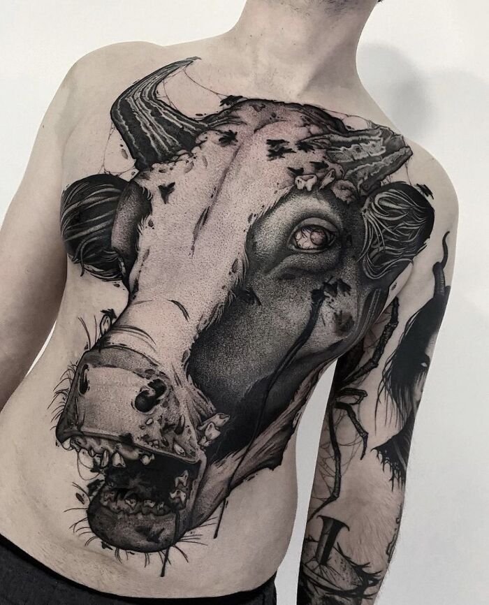 Man with an intricate cow tattoo covering his chest, emphasizing tattoos that may not have been well thought through.