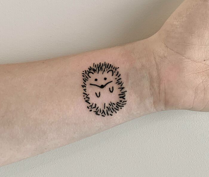 Minimalist hedgehog wrist tattoo design.