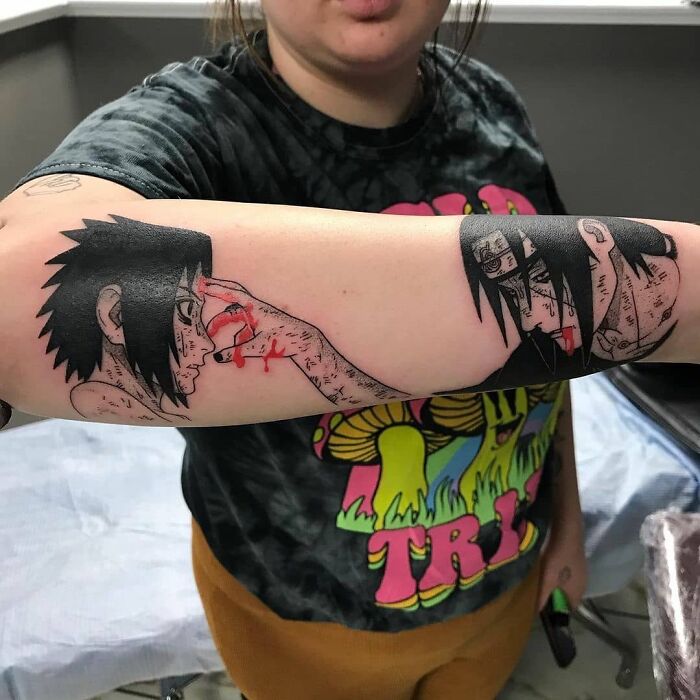 Forearm adorned with pop culture tattoo featuring anime characters, showcasing bold, detailed artwork.