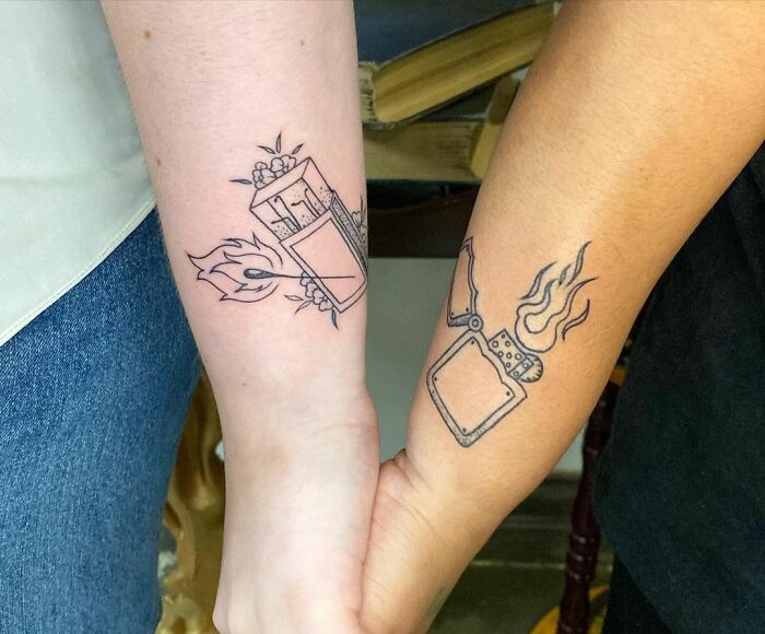 Matching tattoos on two arms featuring a lighter and matchstick, symbolizing connection and unity.
