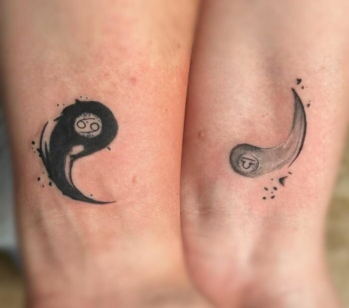 Matching tattoos for couples with yin-yang design on two forearms.