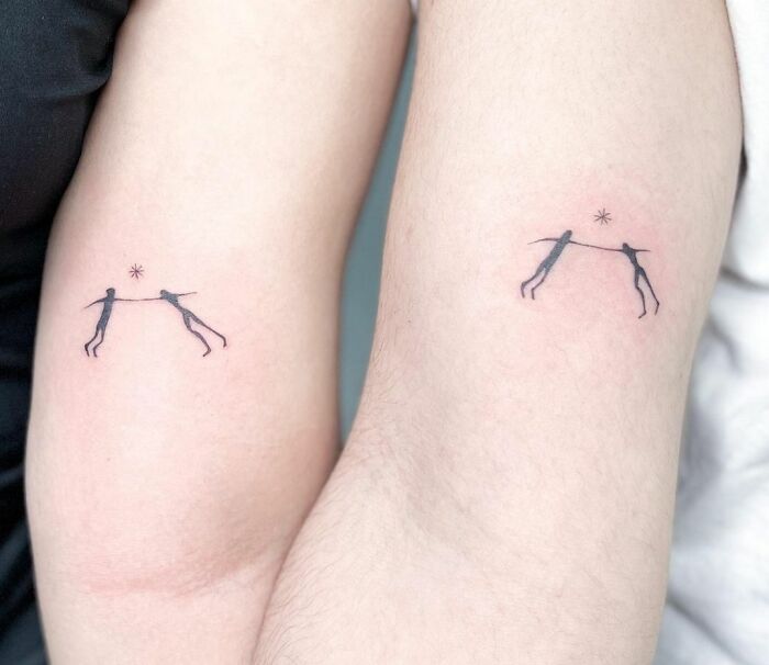 Matching tattoos on arms with two stick figures holding hands and a star symbol, perfect for special people in your life.