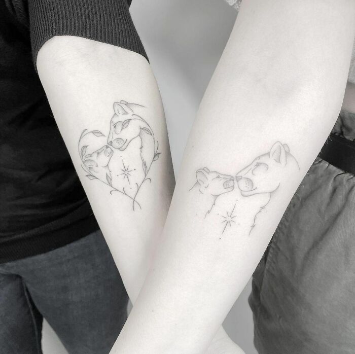 Matching tattoos on forearms featuring two shaded animal figures, symbolizing bond and connection.