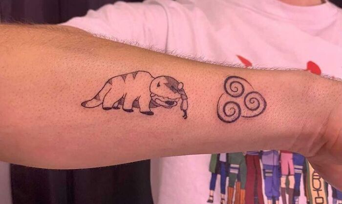 Arm tattoo featuring Appa and airbending symbol from pop culture.