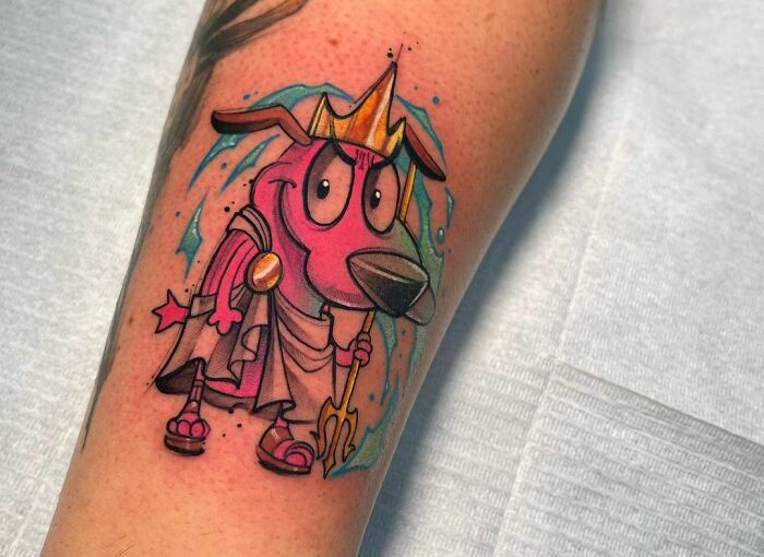 Pop culture tattoo featuring a cartoon dog character dressed as a king on a person's arm.