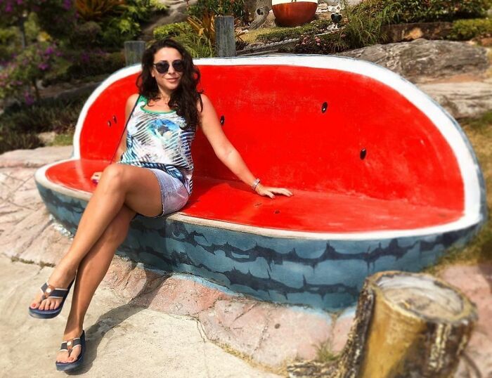 Woman sitting on the color watermelon shaped stone bench