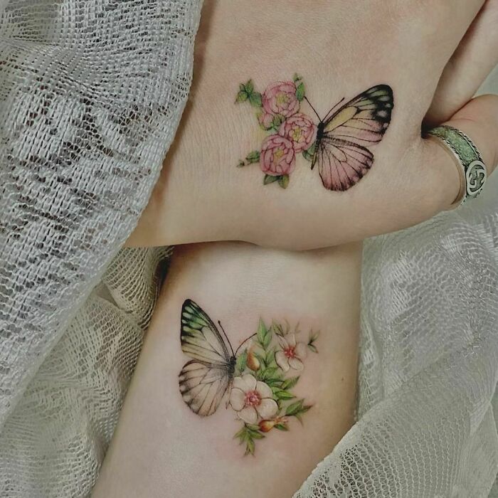 Small hand tattoos featuring delicate butterflies and flowers on wrists, showcasing intricate and artistic designs.