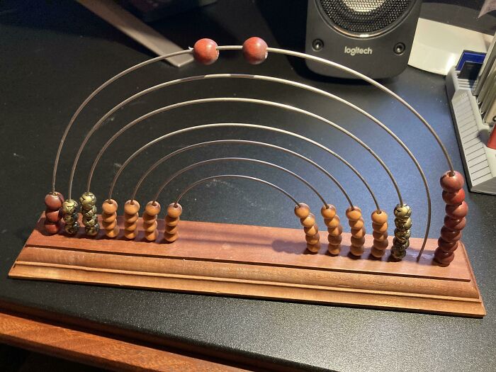 Weird Semi Circle Wires With Various Beads On A Wooden Plank Found In An Older House