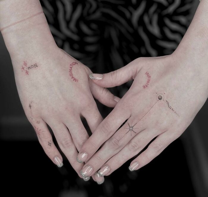 Hands with small, intricate tattoos featuring text and minimalist designs, showcasing creative tattoo ideas.