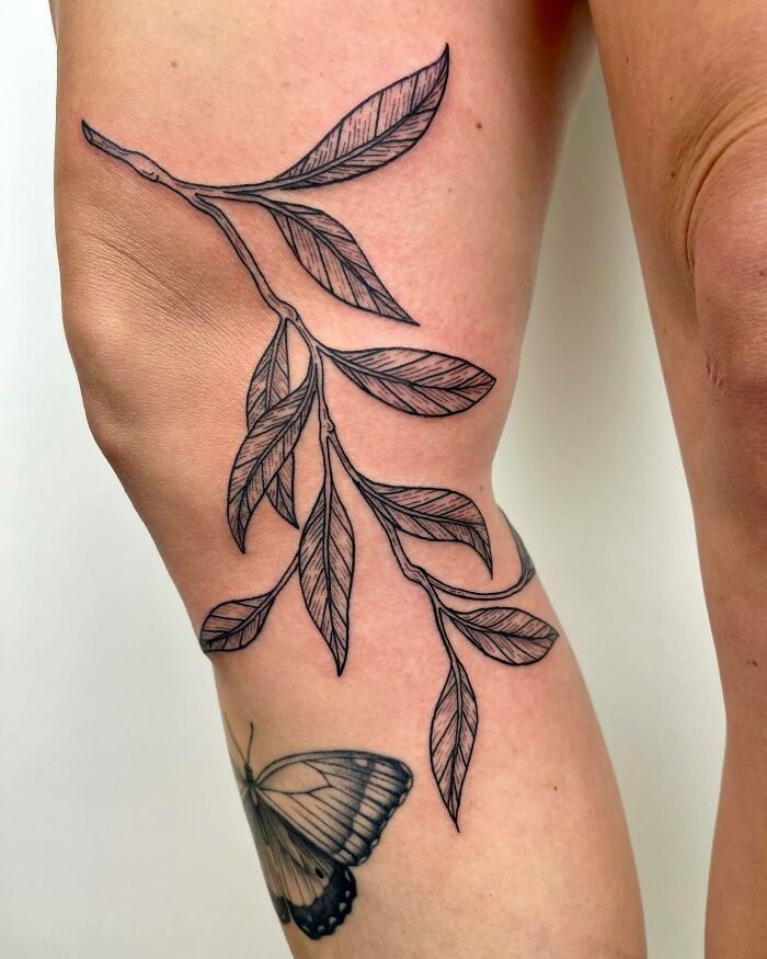 Leaf and butterfly knee tattoo design showcasing artistic detail.